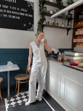A woman wears triacetate vest and jeans